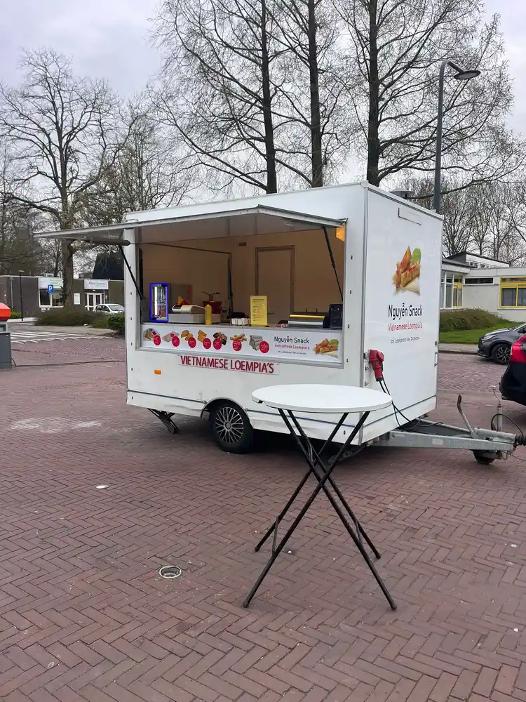 Voorkant van de Nguyễn Snack foodtruck met statafel op de Wardhof in Dronten Zuid